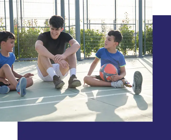 Kids sitting on a basketball court